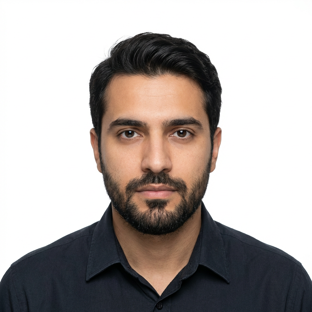Professional studio headshot of a man Head-and-shoulders portrait of a man with dark hair and a beard.